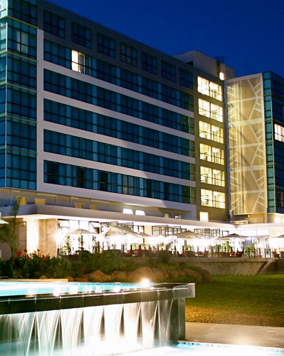 Mount Meru Hotel lit up at dusk with its poolside terrace