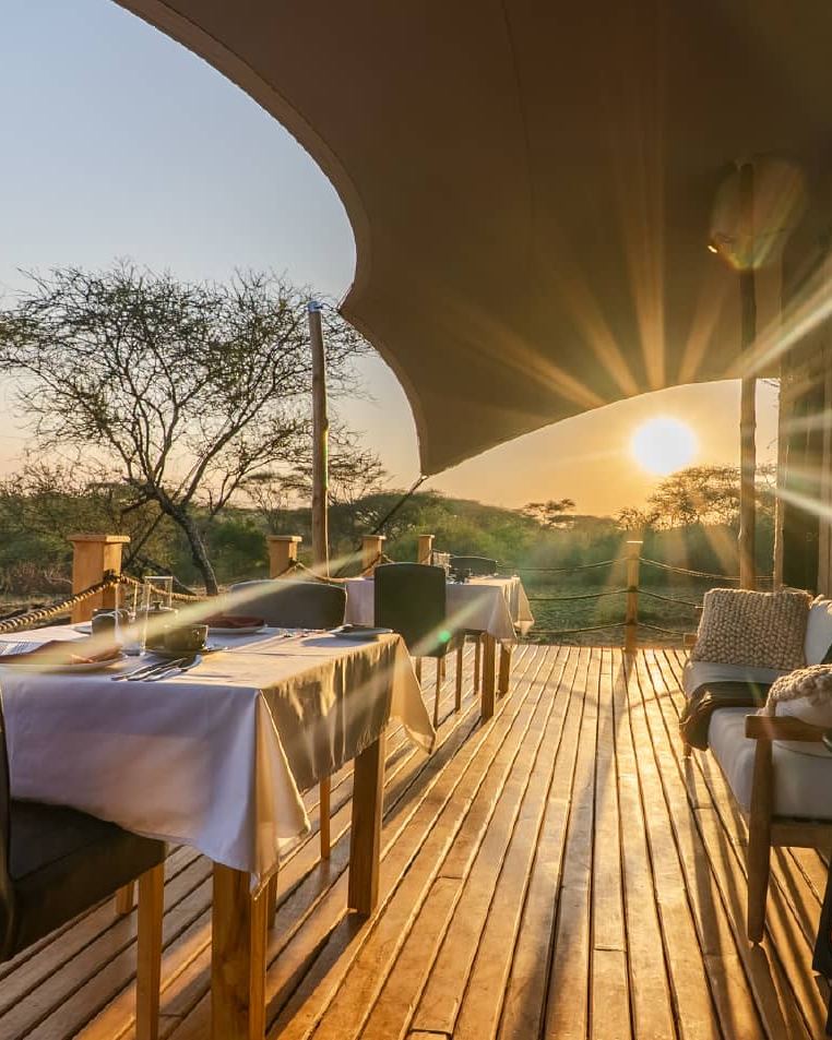Tabi lodge dining deck at sunset overlooking acacia bush